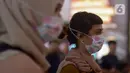 Calon penumpang kereta api mengenakan masker saat berada di Stasiun Gambir, Jakarta Pusat, Jumat (31/01). Dalam rangka pencegahan Virus Corona, PT Kereta Api Indonesia (persero) melakukan sosialisasi kepada penumpang dengan membagi-bagikan masker di stasiun Gambir. (merdeka.com/Imam Buhori)