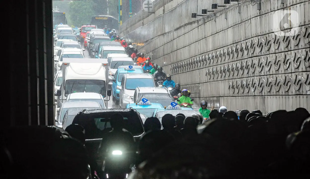 Pengendara sepeda motor yang berteduh dengan berhenti di badan jalan Underpass Mampang membuat arus lalu lintas tersendat. (merdeka.com/Arie Basuki)