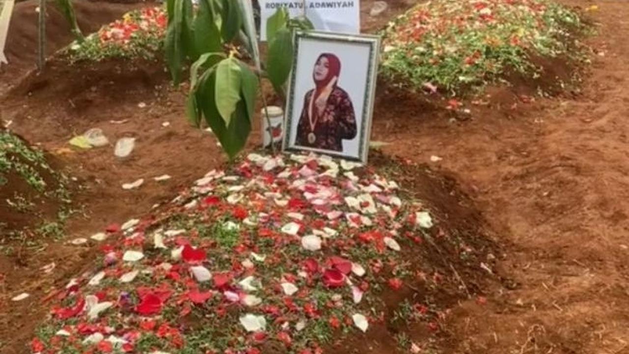 Dalam potret ini, tampak dua orang yang tengah mengunjungi makam teman-temannya.