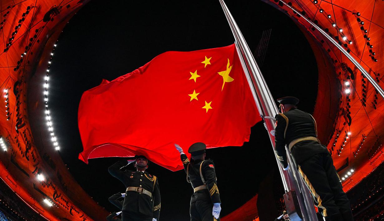 Bendera nasional Tiongkok dikibarkan selama upacara pembukaan Olimpiade Musim Dingin Beijing 2022, di Stadion Nasional, yang dikenal sebagai Stadion Bird's Nest, di Beijing, pada 4 Februari 2022. (AFP/Lillian Suwanrumpha)