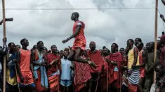 Pria suku Masaai melompat untuk mencapai tali selama mengikuti Olimpiade Maasai 2018 di Kimana, Kenya (15/12). Olimpiade ini inisiatif dari kelompok konservasi internasional yang dipimpin oleh Born Free. (AFP Photo/Yasuyoshi Chiba)