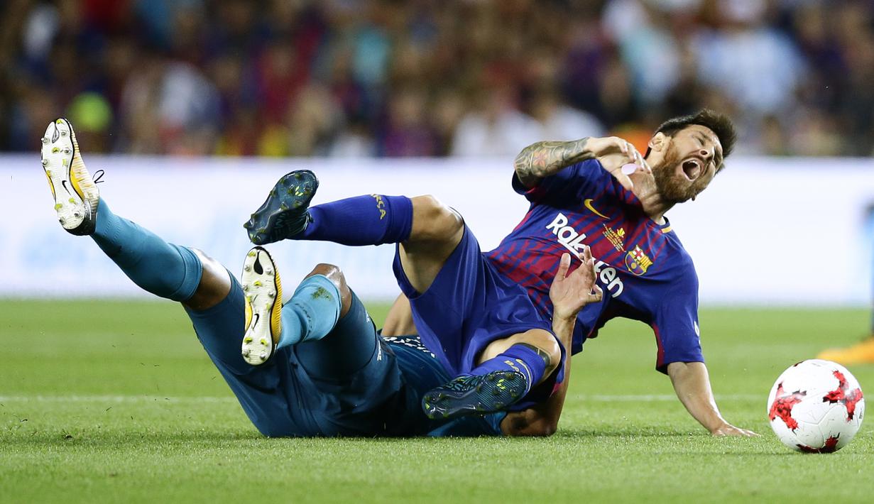 Lionel Messi dilanggar pemain Real Madrid pada laga Supercup Spanyol di Camp Nou stadium, Barcelona, (13/8/2017). Real Madrid menang 3-1. (AP/Manu Fernandez)