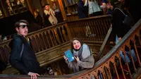 Seorang wanita memegang buku Harry Potter di toko buku Lello, Porto, Portugal, Sabtu (12/1). Toko buku Lello diduga menginspirasi JK Rowling untuk menulis Harry Potter. (MIGUEL RIOPA/AFP)