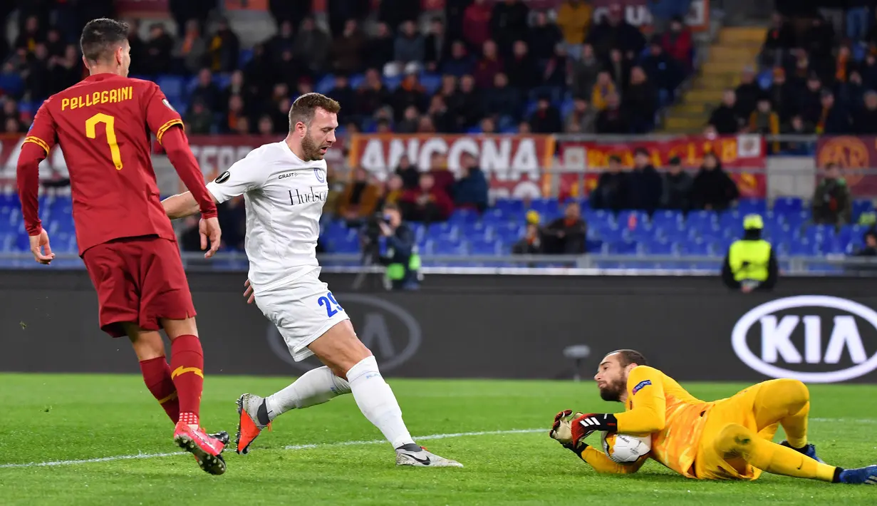 Kiper AS Roma Pau Lopez (kanan) melakukan aksi penyelamatan saat melawan Gent pada leg pertama babak 32 besar Liga Europa di Olympic Stadium, Roma, Italia, Kamis (20/2/2020). Gol tunggal Carles Peres membawa AS Roma menaklukkan Gent 1-0. (Alberto PIZZOLI/AFP)