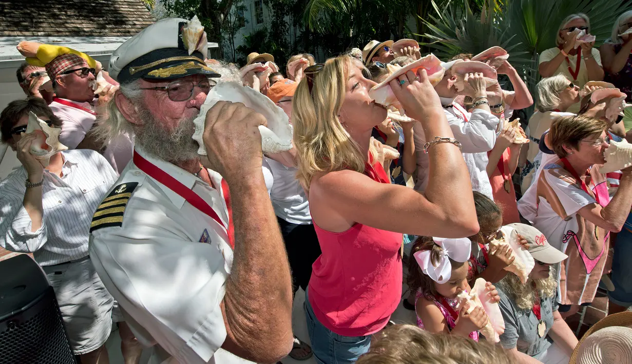 Peserta berkumpul untuk meniup bersama-sama saat lomba meniup tempurung kerang di Key West, Florida, AS, Sabtu (4/3). Lomba meniup tempurung kerang menjadi acara yang ditunggu-tunggu setiap tahun di Florida. (AFP PHOTO/ Rob O'Neal)
