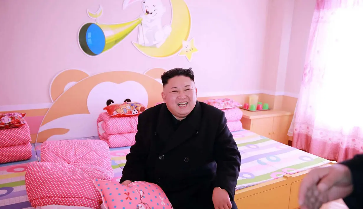 Senyum Kim Jong Un saat melihat ruangan kamar asrama murid Sekolah Dasar Anak Yatim di Pyongyang (2/2). (AFP Photo / KCNA VIA KNS / STR)