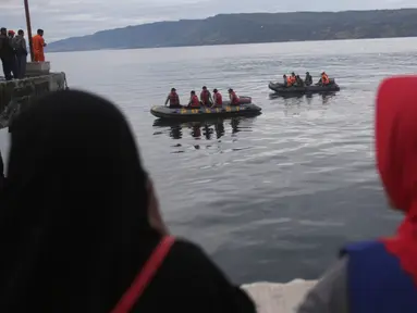 Personel Basarnas melakukan pencarian korban KM Sinar Bangun yang tenggelam di Danau Toba, Sumatra Utara, Rabu (20/6). Hingga hari ketiga, sebanyak 18 penumpang selamat, dua tewas dan 160 lainnya masih dalam proses pencarian. (AP/Binsar Bakkara)Petugas ga
