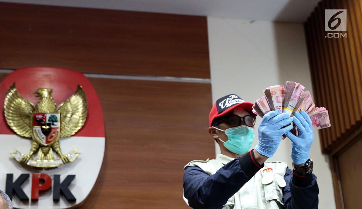 Petugas KPK menunjukkan barang bukti hasil OTT terhadap Bupati Pakpak Bharat Sumatera Utara, Remigo Yolanda Berutu di Gedung KPK, Jakarta, Minggu (18/11). KPK menetapkan tiga tersangka dan menyita uang Rp 150 juta. (Liputan6.com/Helmi Fithriansyah)