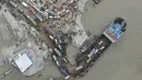 Foto udara yang diambil pada 27 Juni 2021 ini memperlihatkan penumpang naik kapal feri jelang pengetatan lockdown, Munshiganj, Bangladesh. Pembatasan aktivitas dan pergerakan sebenarnya telah dilakukan sejak pertengahan April karena kasus dan kematian terkait COVID-19 melonjak. (Munir Uz zaman/AFP)