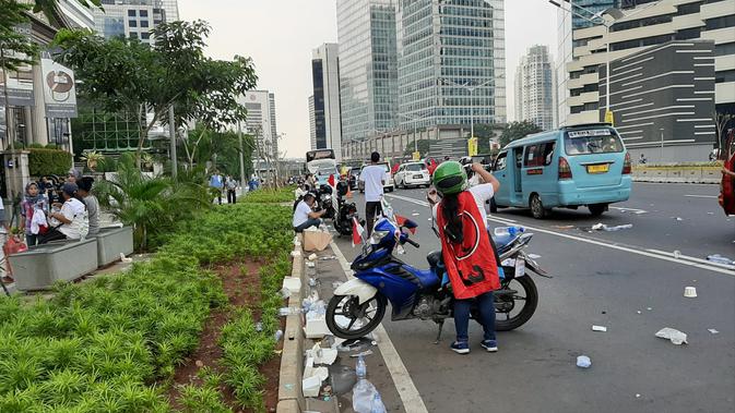 Sampah plastik dan bekas makanan tampak berserakan di trotoar dan pembatas Jalan MH Thamrin.