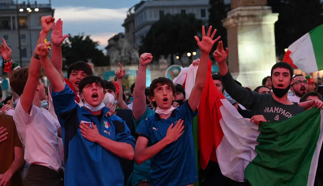Fans Italia menonton di layar raksasa dari zona penggemar resmi di Piazza del Popolo di Roma pada laga pertama grup A Euro 2020 /2021 Turki vs Italia, Jumat (11/6/2021). Timnas Italia berhasil menang 3-0 atas Turki. (ANDREAS SOLARO/AFP)