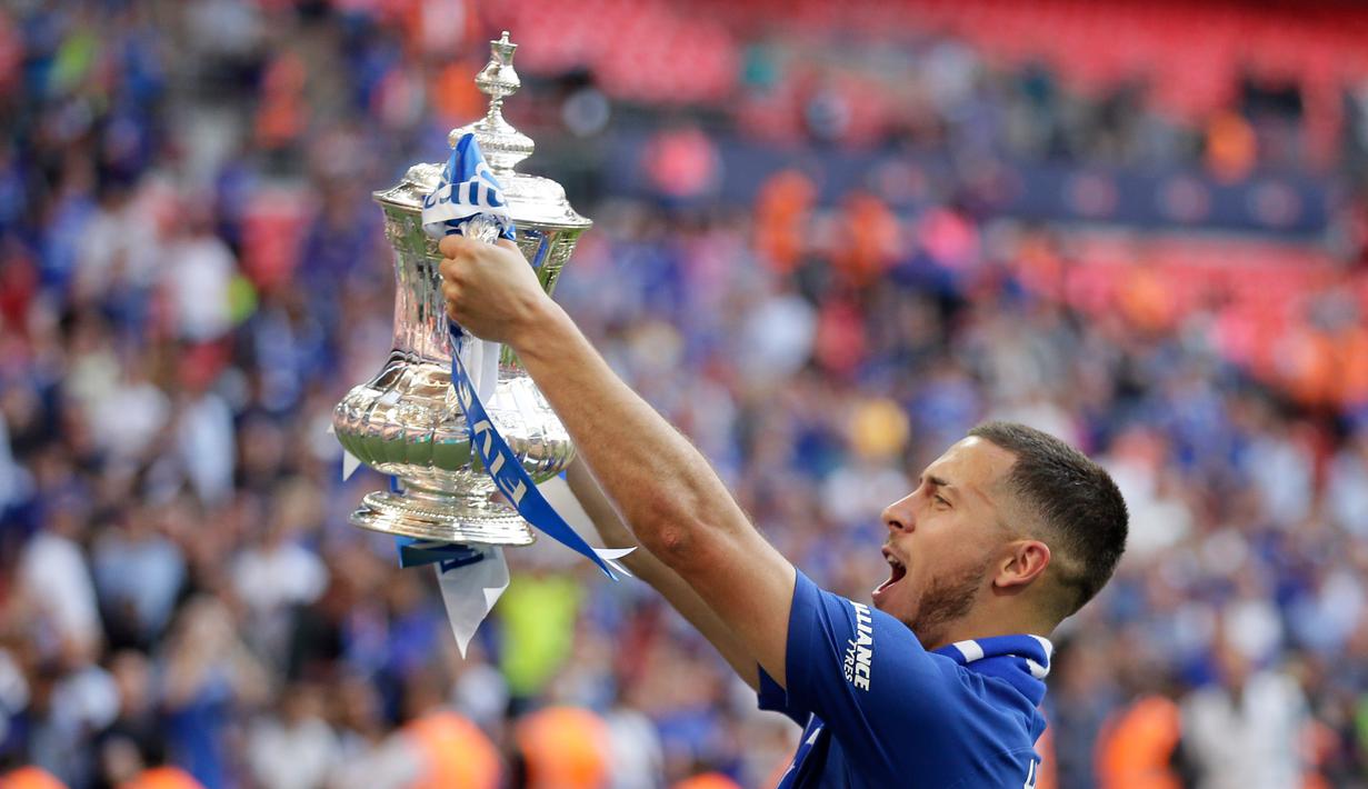 Gelandang Chelsea, Eden Hazard mengangkat trofi Piala FA usai pertandingan melawan Manchester United pada babak final Piala FA di stadion Wembley di London (19/5). Chelsea mengalahkan MU 1-0. (AP Photo / Tim Ireland)