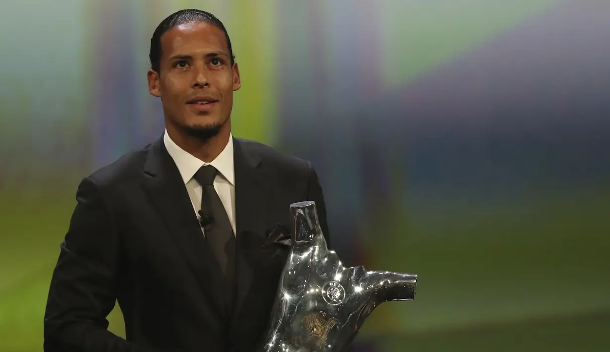 Bek Liverpool Virgil van Dijk memegang piala penghargaan Pemain Terbaik Eropa 2018-2019 selama undian babak grup di Grimaldi Forum, Monako, Kamis (29/8/2019). Virgil van Dijk berhasil mengungguli Lionel Messi dan Cristiano Ronaldo. (AP Photo/Daniel Cole)