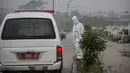 Sebuah mobil van membawa jenazah korban virus Corona Covid-19 untuk dimakamkan di tengah hujan lebat di pemakaman Keputih, Surabaya (7/1/2020). Penambahan kasus baru Covid-19 di Indonesia mencapai 9.321 dalam sehari dan merupakan rekor tertinggi. (AFP/Juni Kriswanto)