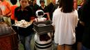 Robot mengumpulkan piring-piring tamu yang telah kotor di Chilli Padi Nonya Cafe, Singapura, (6/7).Pengembangan robot di Singapura masih dalam uji coba tetapi sudah banyak perusahaan yang ingin memperkejakan robot. (REUTERS / Edgar Su)