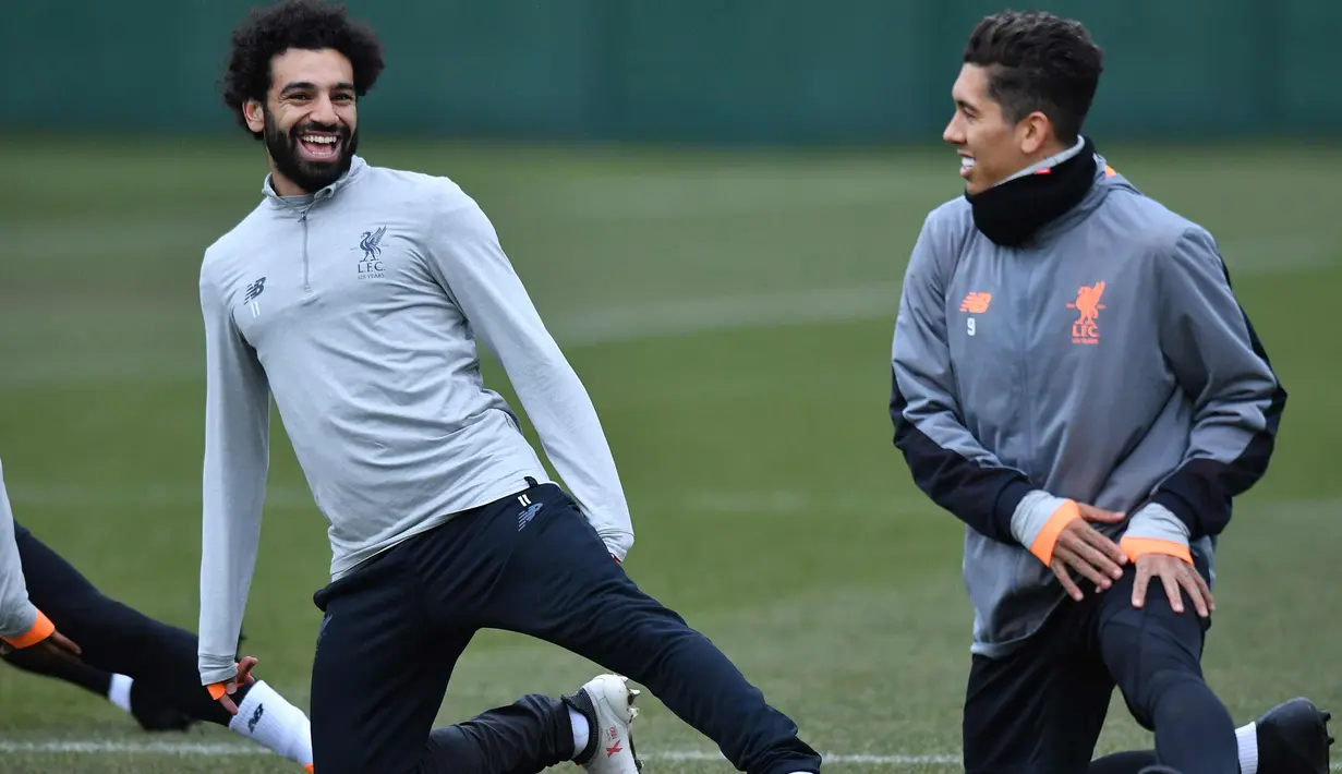 Penyerang Liverpool, Mohamed Salah (kiri) dan Roberto Firmino melakukan pemanasan saat latihan di Melwood Training Ground, Liverpool, Inggris (5/3). Liverpool akan melawan Porto pada leg kedua babak 16 besar Liga Champions. (AFP Photo/Anthony Devlin)
