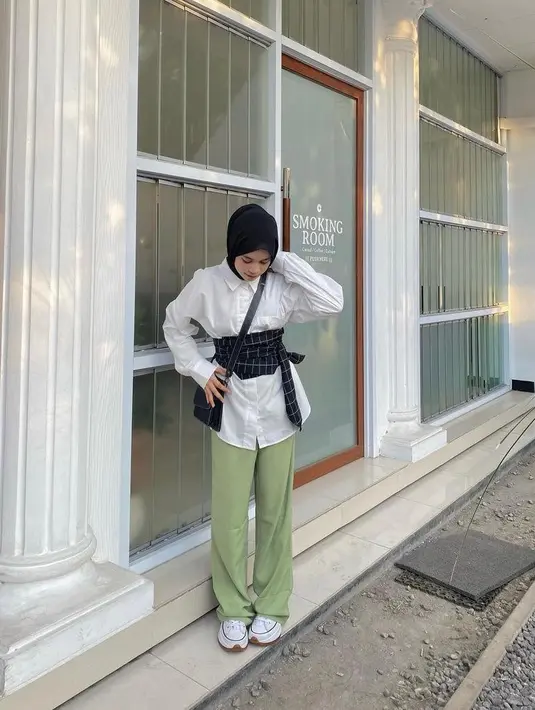 Kemeja putih dan loose pants yang dipadukan dengan obi belt buat penampilan makin stunning. Simple dan stylish. (Instagram/aishaibrahimmm).