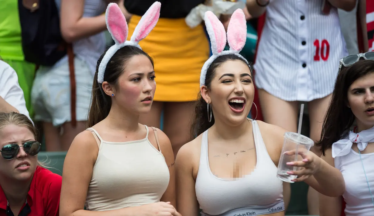 Dua fans wanita memakai atribut kuping kelinci saat menyaksikan pertandingan Rugby Sevens di Hong Kong (9/4). Para wanita yang  ini hadir mengenakan pakaian dan atribut unik demi mendukung tim kesayangannya. (AFP Photo / Dale De La Rey)