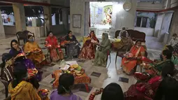 Wanita Hindu melakukan ritual sebelum berbuka puasa sepanjang hari selama festival 'Karwa Chauth', di Jammu, India (4/11/2020). Wanita Hindu yang menikah berpuasa dan berdoa ke bulan untuk kesejahteraan, kemakmuran, dan umur panjang suami mereka di festival ini. (AP Photo/Channi Anand)