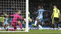 Pemain Manchester City, Kelechi Iheanacho (tengah) mengecoh kiper Huddersfield Town dengan golnya pada laga Piala FA putaran kelima di Etihad stadium, Manchester, Wednesday, (1/3/2017). Man.City menang 5-1. (AP/Dave Thompson)