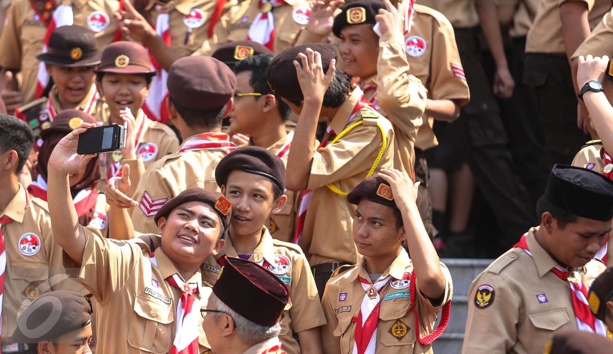 Seorang Pria asik berfoto dengan teman – temannya di Halaman Istana Merdeka, Jakarta, Jumat (24/7/2015). Sebanyak 462 kontingen Pramuka Indonesia akan berkiprah di Jambore Dunia ke-23 di Kirarahama, Yamaguchi, Jepang. (Liputan6.com/Faizal Fanani)