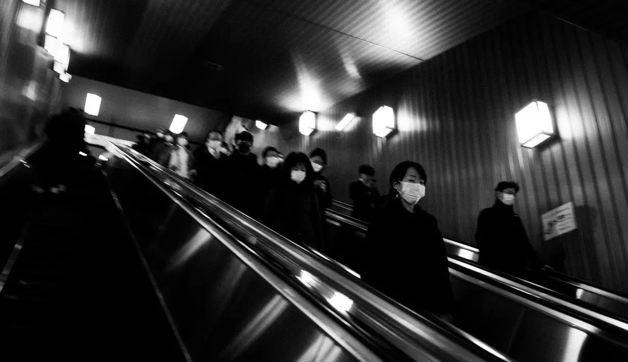 Penumpang naik eskalator di stasiun kereta api di Tokyo, (9/3/2020). (AP Photo / Jae C. Hong)