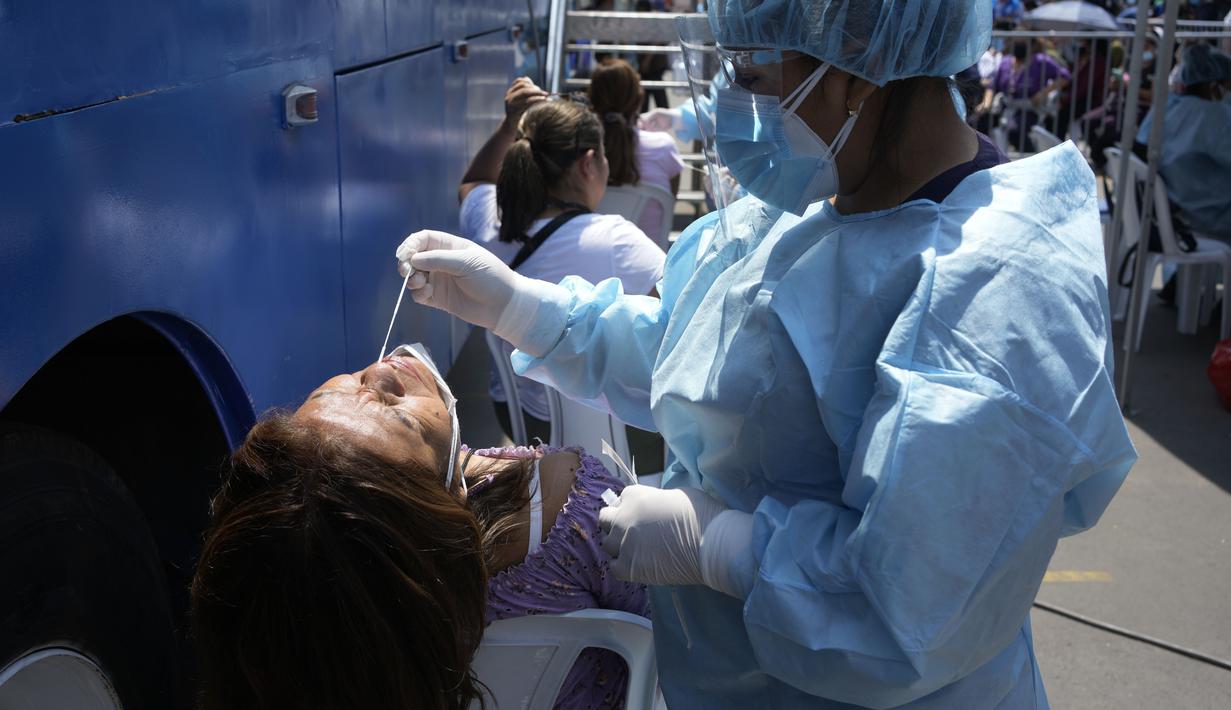 Petugas medis mengambil sampel untuk tes PCR COVID-19 di sebuah pasar di Lima, Peru, Rabu (5/1/2022). Peru mengonfirmasi pada Selasa dimulainya gelombang ketiga infeksi virus corona di mana negara itu mencatat 309 kasus varian omicron yang sangat menular. (AP Photo/Martin Mejia)