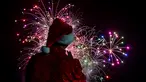 Seorang pria mengenakan kostum santa melihat kembang api selama parade Natal di Panama City (16/12). Warga Panama tengah mempersiapkan diri menyambut datangnya Natal 2018 yang jatuh pada tanggal 25 Desember. (AFP Photo/Luis Acosta)