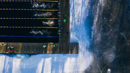 Pemandangan udara ini menunjukkan orang-orang saat mereka berpartisipasi dalam Kejuaraan Berenang Musim Dingin Swedia di Hellasgarden, Stockholm pada 5 Februari 2022. Kejuaraan renang tersebut digelar dengan suhu air tidak lebih dari 1,9 derajat celsius. (Jonathan NACKSTRAND / AFP)