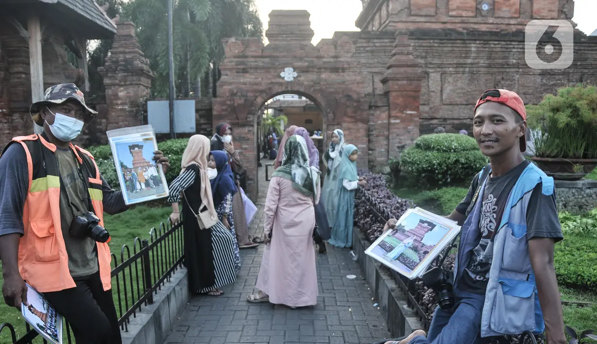 Fotografer keliling menawarkan jasanya kepada peziarah Makam Sunan Kudus, Kauman, Kabupaten Kudus, Jawa Tengah, Rabu (30/3/2022). Musim ziarah membawa berkah tersendiri bagi para fotografer keliling di kawasan Makam Sunan Kudus. (merdeka.com/Iqbal S. Nugroho)