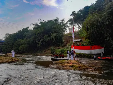 Peserta mengikuti upacara pengibaran bendera, di Sungai Ciliwung kawasan GDC, Depok, Jawa Barat, Sabtu (17/8/2024). (merdeka.com/Arie Basuki)