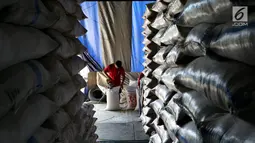 Pekerja mamasukan beras ke dalam karung di Pasar Induk Beras Cipinang, Jakarta Timur, Kamis (24/8). Sementara untuk wilayah lainnya yang membutuhkan ongkos transportasi lebih harga tersebut ditambah Rp 500 per kg. (Liputan6.com/Johan Tallo)