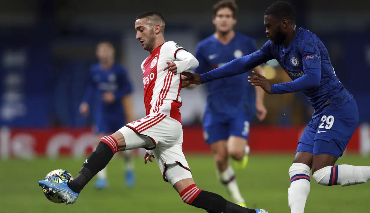 Gelandang Ajax, Hakim Ziyech mengontrol bola dari kawalan bek Chelsea, Fikayo Tomori pada pertandingan lanjutan Grup H Liga Champions di Stamford Bridge, London (5/11/2019). Chelsea bermain imbang 4-4 atas Ajax. (AP Photo/Frank Augstein)