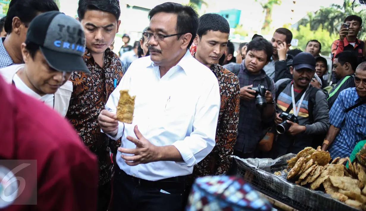 Wagub DKI, Djarot Saiful Hidayat mencicipi gorengan saat menyapa pedagang kaki lima (PKL) di kawasan Mangga Dua, Jakarta, Selasa (25/10). Djarot mensosialisasikan PKL agar berdagang di tempat yang telah disediakan Pemprov. (Liputan6.com/Faizal Fanani)