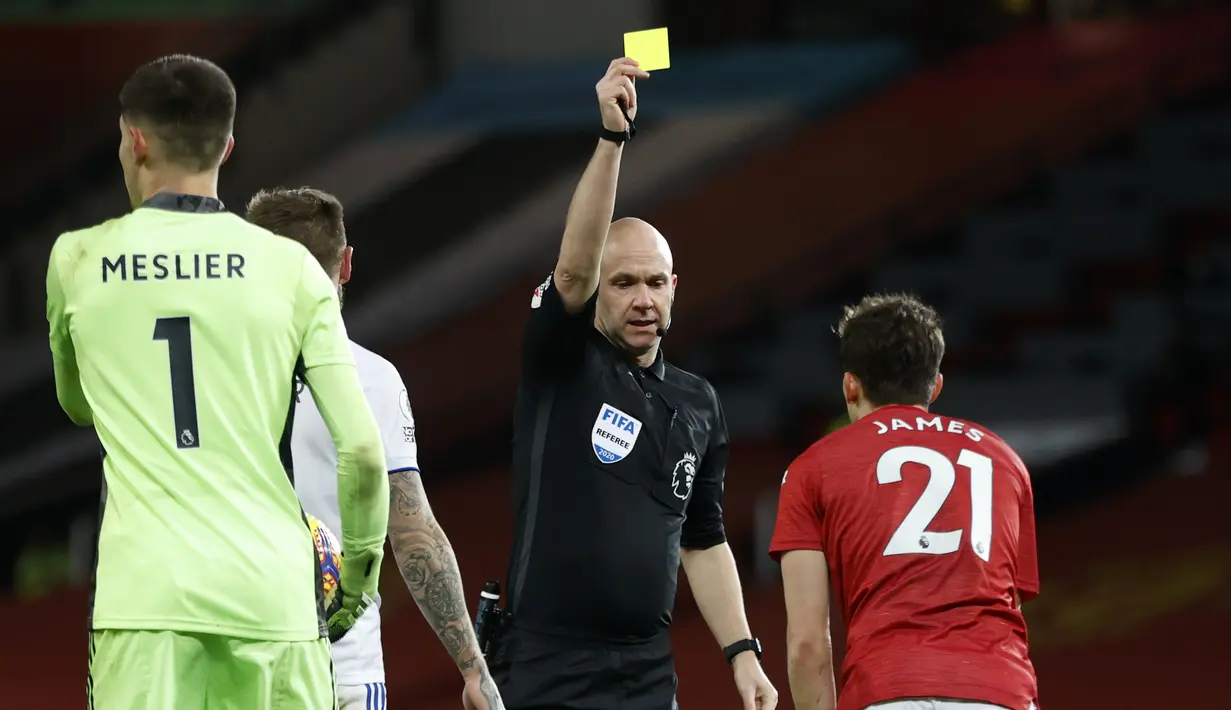 Wasit Anthony Taylor memberikan kartu kuning kepada gelandang Manchester United, Daniel James, dalam laga lanjutan Liga Inggris 2020/21 pekan ke-14 melawan Leeds United di Old Trafford Stadium, Minggu (20/12/2020). Leeds United kalah 2-6 dari Manchester United. (AFP/Clive Brunskill/Pool)