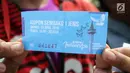 Warga menunjukkan kupon yang akan ditukarkan sembako gratis dalam acara "Untukmu Indonesia" di lapangan Monas, Jakarta, Sabtu (28/4). (Liputan6.com/Arya Manggala)