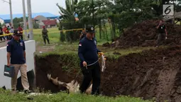 Petugas Puslabpor Bareskrim Polri membawa alat ukur saat olah TKP longsornya Underpass Perimeter Selatan, Bandara Soekarno Hatta (Soetta), Tangerang, Banten, Selasa (6/2). Satu orang tewas dalam kejadian tersebut. (Liputan6.com/Angga Yuniar)
