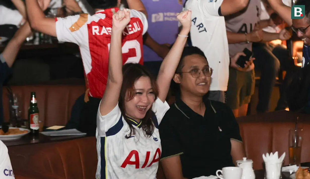 Selebrasi seorang penggemar wanita Tottenham Hotspur saat tim kesayangannya mencetak gol ke gawang Arsenal dalam acara nonton bareng Roaring Night Liga Inggris 2023/2024 di Treehaus Kemang, Minggu (28/4/2024) malam WIB yang digelar komunitas penggemar Tottenham Hotspur, IndoSpurs Jakarta. (Bola.com/Abdul Aziz)