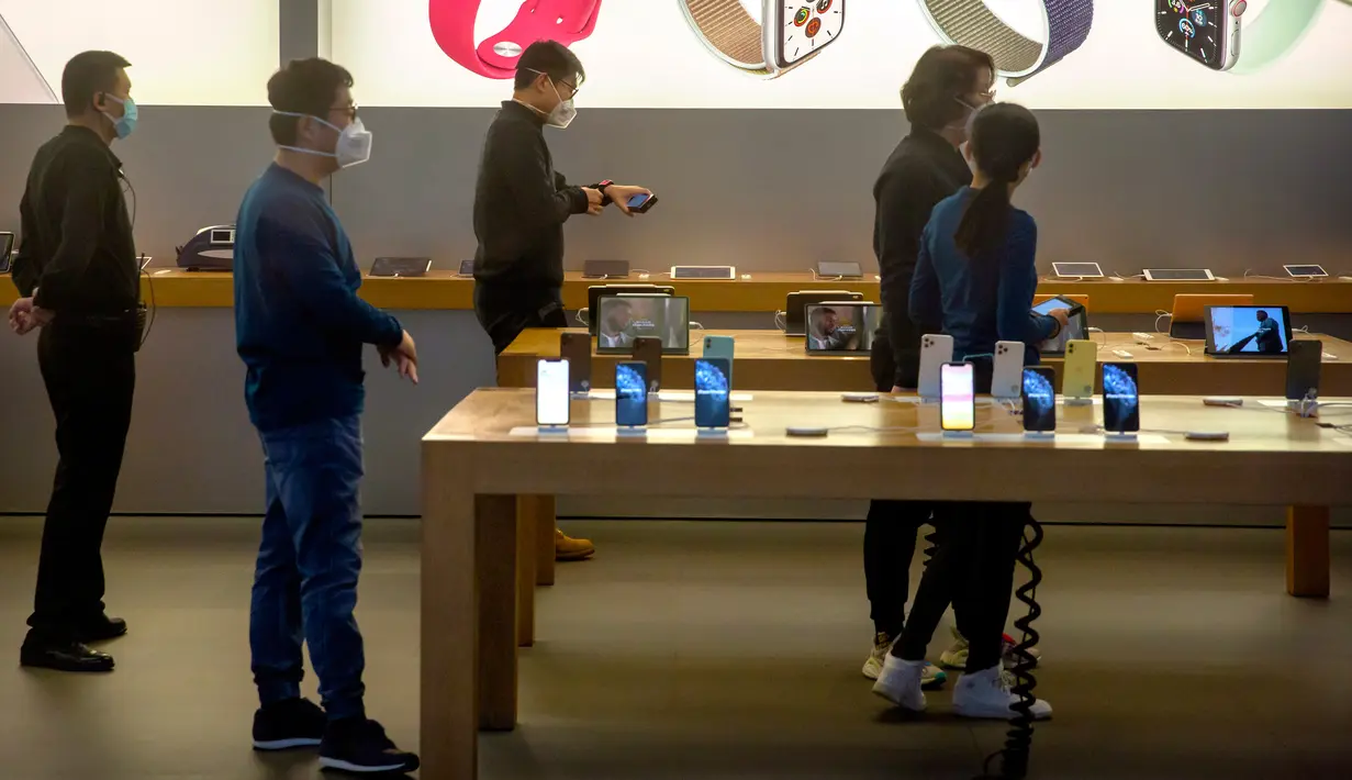 Para pekerja mengenakan masker saat menjaga Apple Store yang dibuka kembali di Beijing, China, Jumat (14/2/2020). Sejauh ini dikabarkan baru lima Apple Store yang dibuka kembali di China. (AP Photo/Mark Schiefelbein)