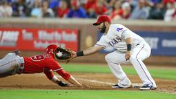 Pemain Texas Rangers, Mitch Moreland #18 dan Pemain Los Angeles, Rafael Ortega #39 oberebut pit pada inning ketujuh pertandingan Baseball di Global Life Park, Arlington, Texas. (23/5/2016). (Rick Yeatts/Getty Images/AFP)
