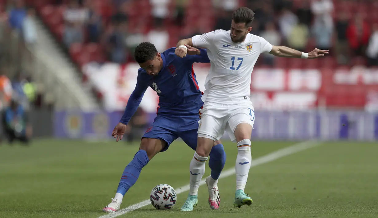 Gelandang Timnas Inggris, Ben Godfrey berebut bola dengan gelandang Timnas Rumania, Adrian Paun pada laga pemanasan jelang Piala Eropa 2020 di Riverside Stadium, Minggu (6/6/2021). Bertanding menghadapi Rumania, Inggris menang tipis 1-0. (AP Photo/Scott Heppell, Pool)