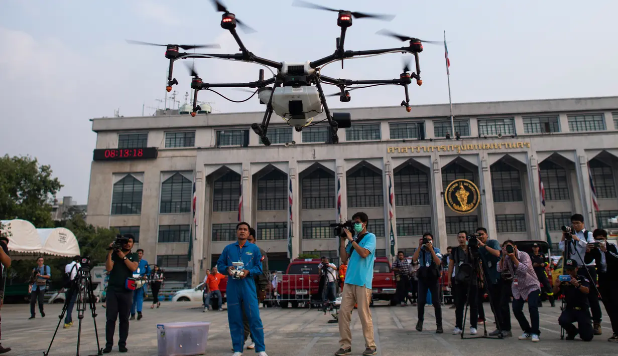 Petugas Administrasi Metropolitan Bangkok (BMA) melihat demonstrasi drone untuk menurunkan hujan buatan, Kamis (31/1). Thailand mengerahkan drone untuk menyemprotkan air dalam membantu memerangi polusi udara di Ibu Kota yang makin parah. (Jewel SAMAD/AFP)