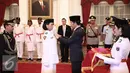 Presiden Jokowi memberikan sabuk sebagai tanda telah dikukuhkan dalam Upacara Pengukuhan Pasukan Pengibar Bendera Pusaka (Paskibraka) di Istana Negara, Jakarta, Senin (15/8). (Liputan6.com/Faizal Fanani)