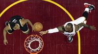 Aksi LeBron James (kanan) memasukan bola melewati adangan pemain Toronto Raptors, Kyle Lowry pada Game 2 pada semifinal Eastern Conference NBA basketball playoff series di Quicken Loans Arena, (3/5/2017). Cavs menang 125-103. (AP/Tony Dejak)