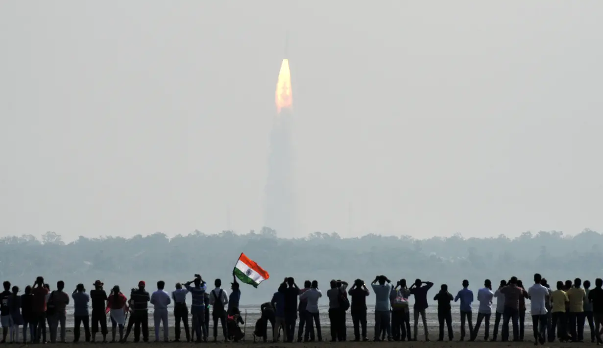 Warga India melihat peluncuran 104 satelit dalam satu misi di pusat antariksa Sriharikota di India timur, Rabu (15/2). Keberhasilan ini membuat India menciptakan rekor dunia dalam peluncuran satelit. (AFP PHOTO/ ARUN SANKAR) 