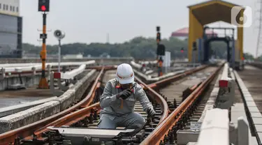 Pekerja melakukan pengecekan arus listrik pada jalur Light Rail Transit (LRT) Jakarta di Depo LRT Jakarta Pegangsaan Dua, Jakarta, Rabu (8/5/2024). (Liputan6.com/Angga Yuniar)
