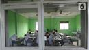 Murid baru menggunakan masker  mengikuti tes penentuan kelas tahun ajaran 2020-2021 yang selanjutnya akan mengikuti kegiatan belajar mengajar (KBM) secara darling di MTs Hidayatul Umami, Cinere, Depok, Jawa Barat, Senin (13/7/2020). (merdeka.com/Arie Basuk)