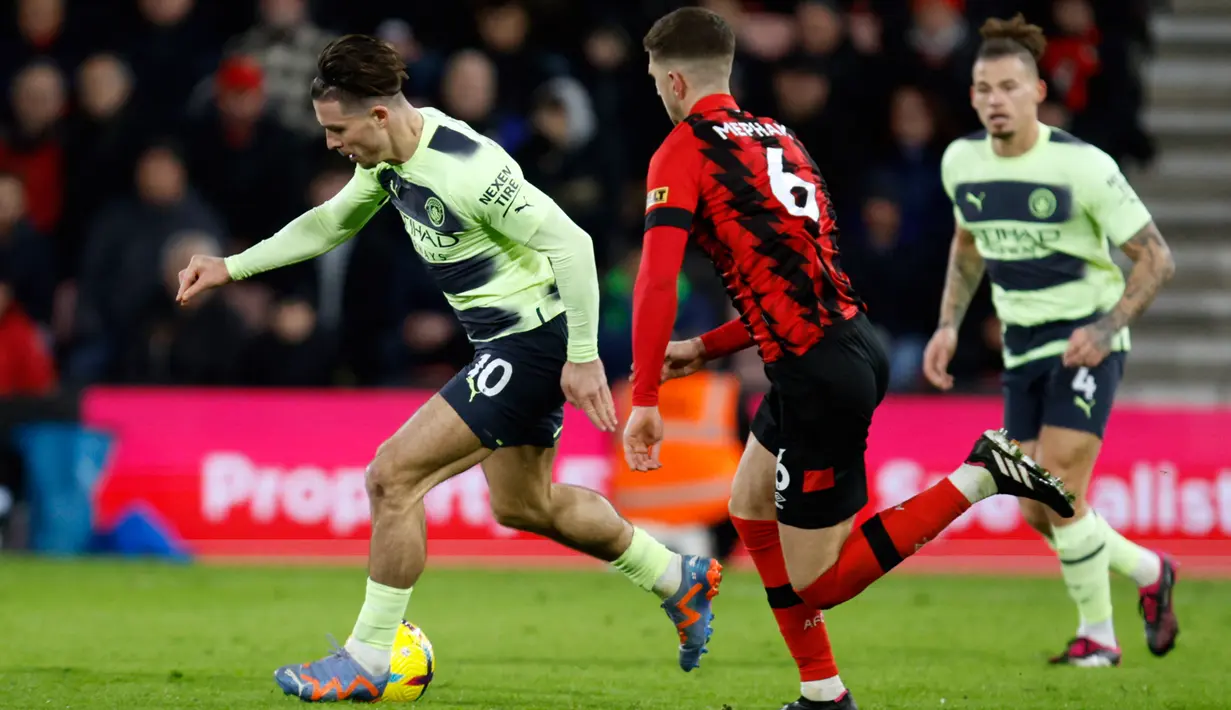 Pemain Manchester City Jack Grealish (kiri) berduel memperebutkan bola dengan pemain Bournemouth Chris Mepham pada pertandingan sepak bola Liga Inggris di Vitality Stadium, Bournemouth, Inggris, 25 Februari 2023. Manchester City mengalahkan Bournemouth dengan skor 4-1. (AP Photo/David Cliff)