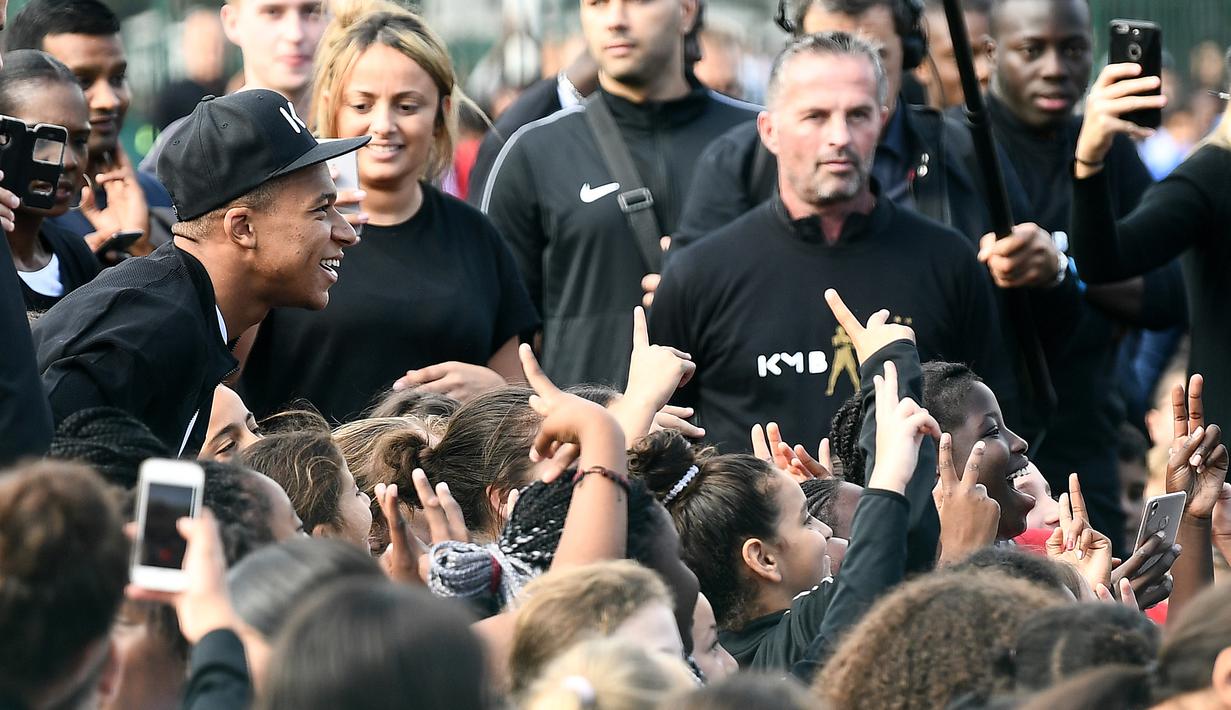 Bintang Prancis, Kylian Mbappe, menyapa fans saat mengunjungi markas AS Bondy di Paris, Rabu (17/10). Kunjungan ke klub pertamanya ini dilakukan setelah dirinya meraih gelar Piala Dunia 2018. (AFP/Franck Fife)