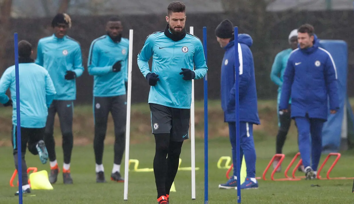 Penyerang Chelsea Olivier Giroud melakukan pemanasan saat latihan di fasilitas latihan Chelsea Cobham di Stoke D'Abernon, sebelah barat daya London (19/2). Chelsea akan bertanding melawan Barcelona di Stamford Bridge. (AFP Photo/Adrian Dennis)